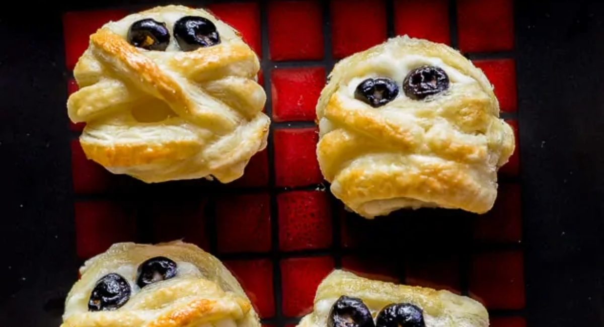 Overhead image of Halloween puff pastry mummy cheese wheels.