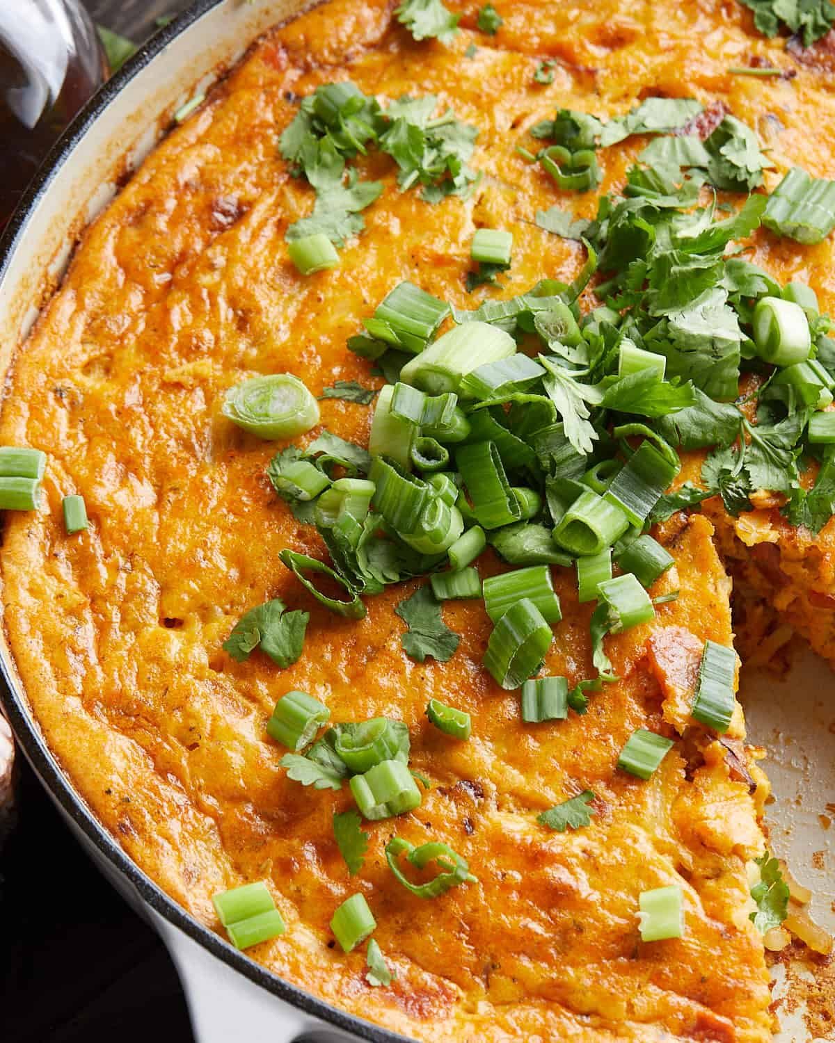 Up close image of ham and cheese hash brown casserole with garnish.