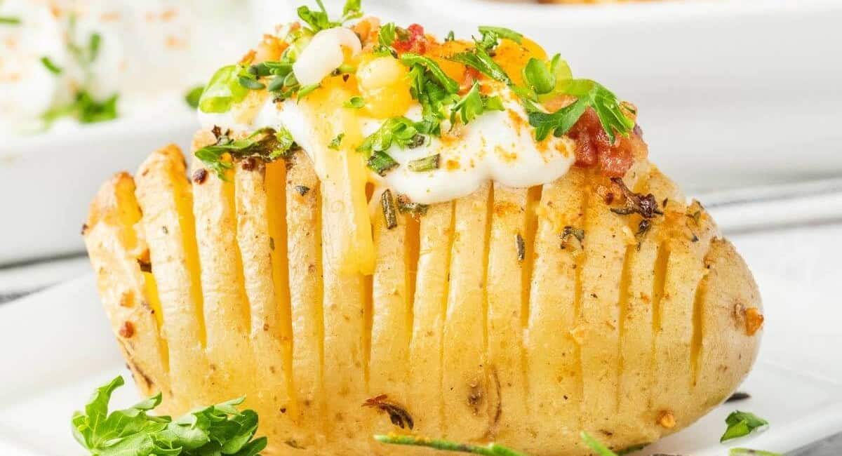 Up close image of air fryer hasselback potatoes with garnish.