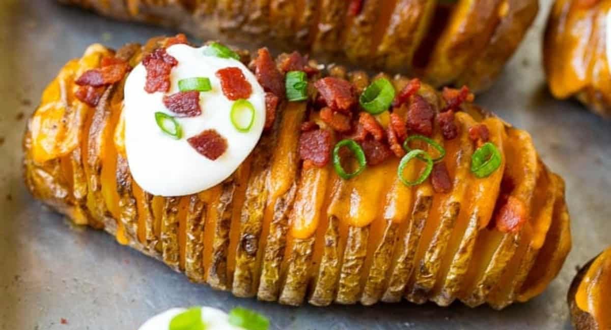 Hasselback potato with bacon, chives and sour cream topping.