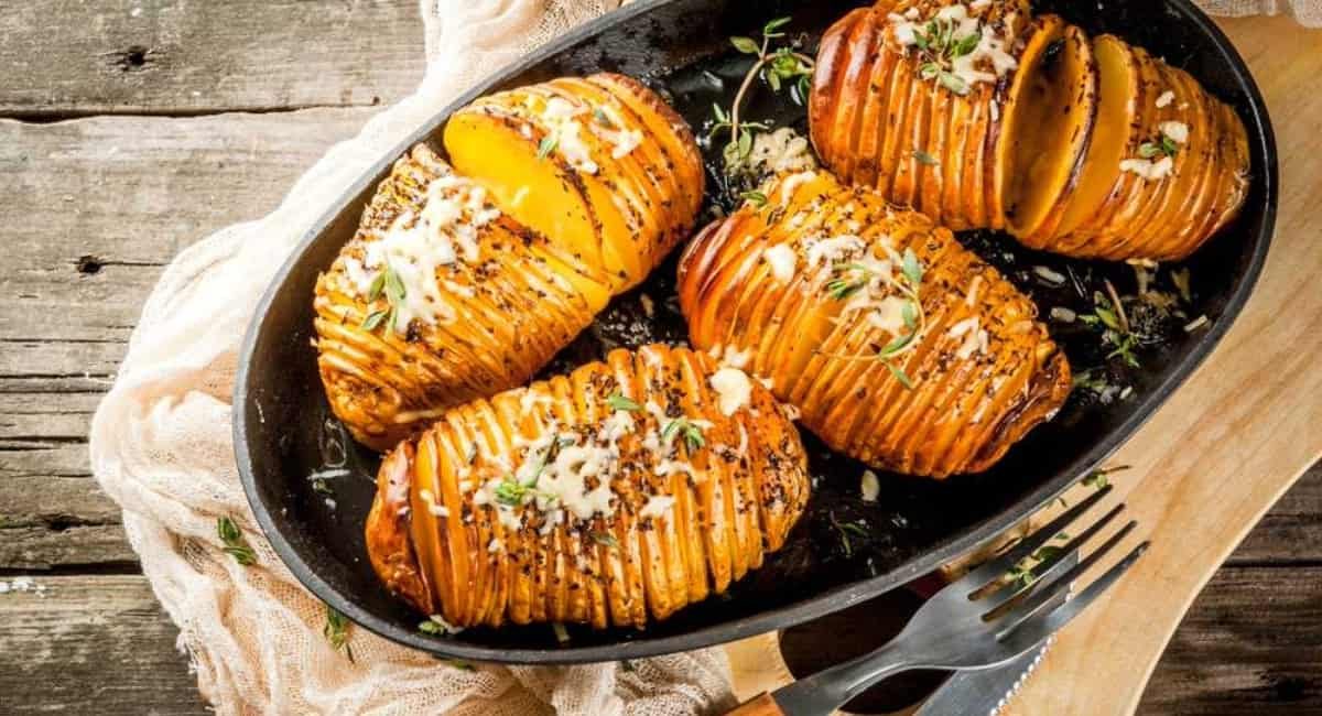 Overhead image of hasselback potatoes with garnish.