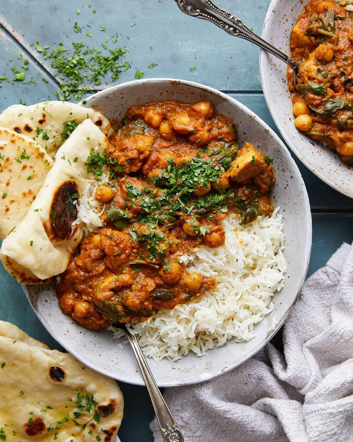 Overhead image of healthy chicken tikka masala in bowl with garnish.