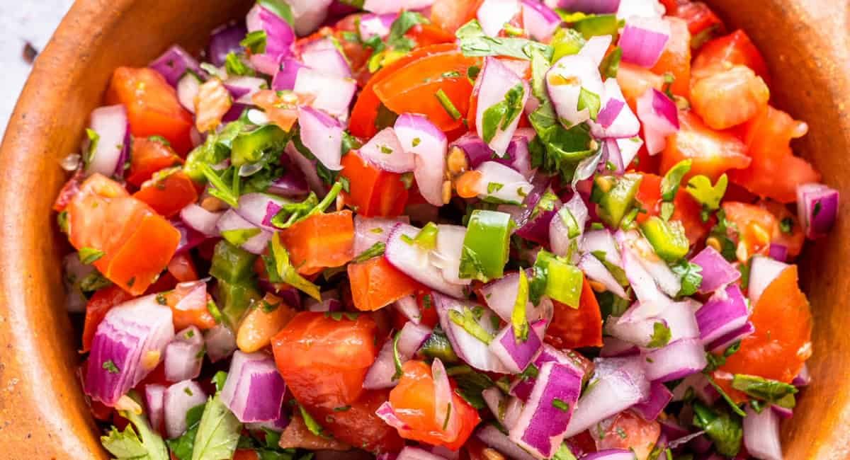 Overhead image of homemade pico de gallo in brown dish.