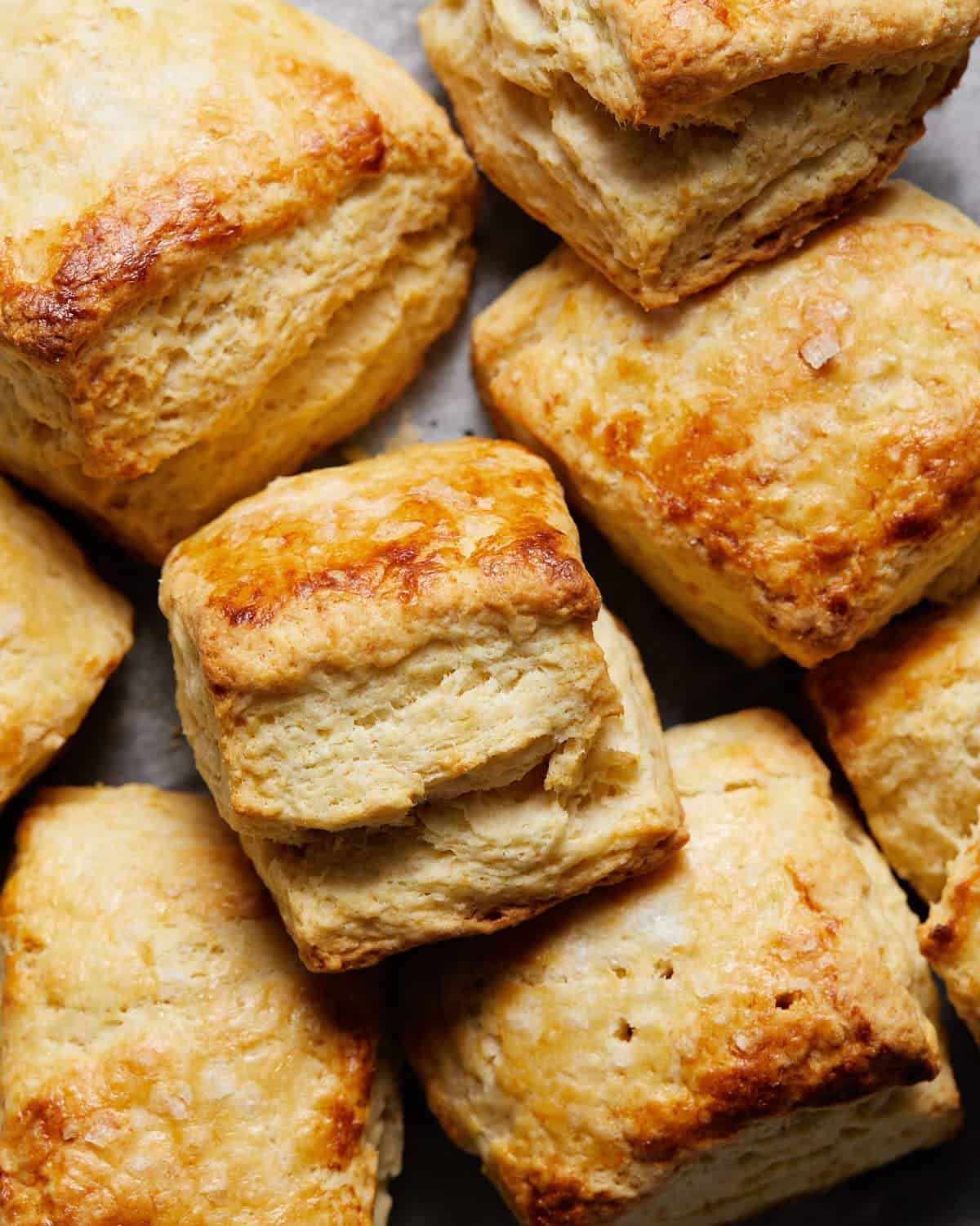 Easy homemade biscuits stacked up on baking sheet.
