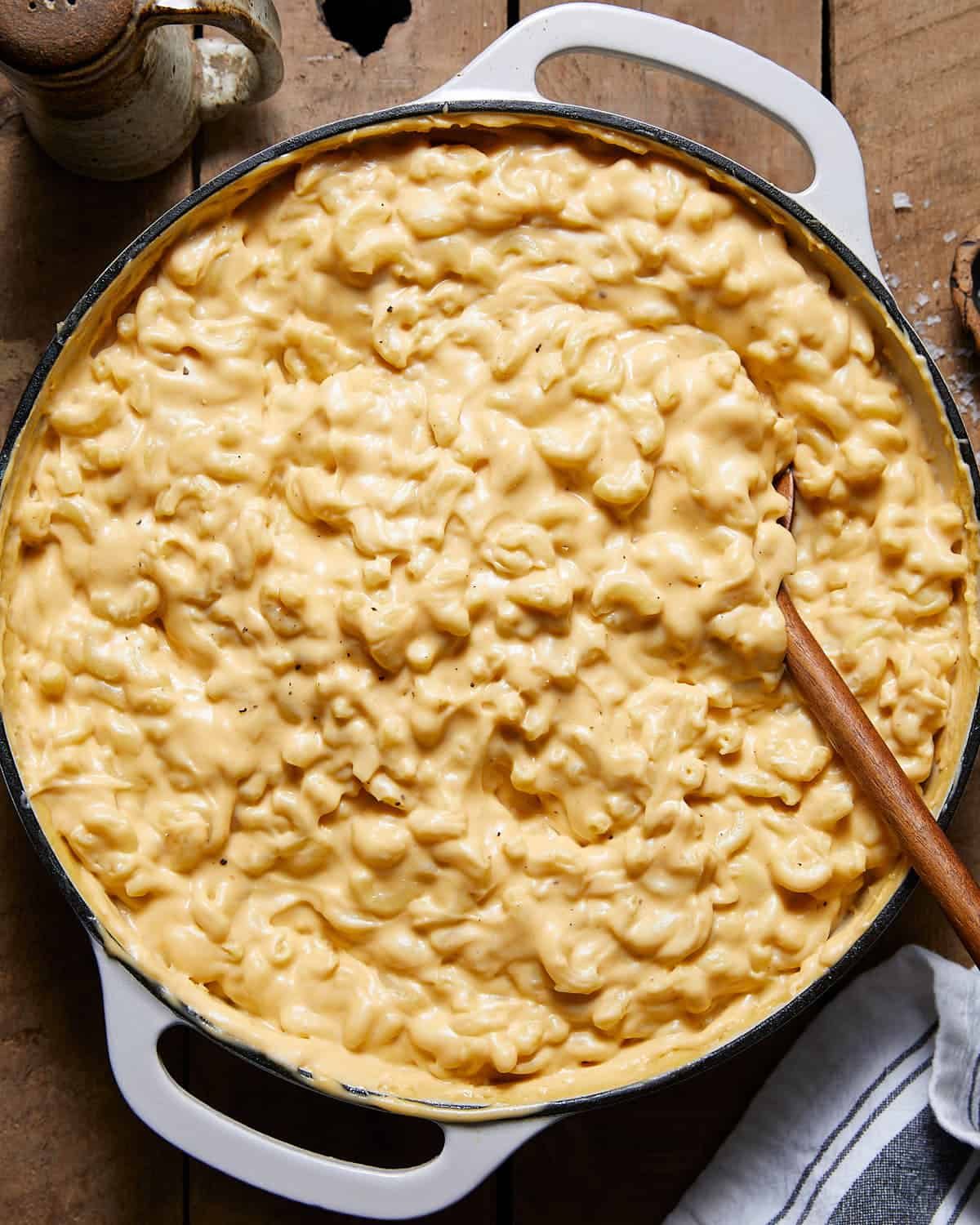 Mac and cheese sauce tossed with pasta in a white pot.