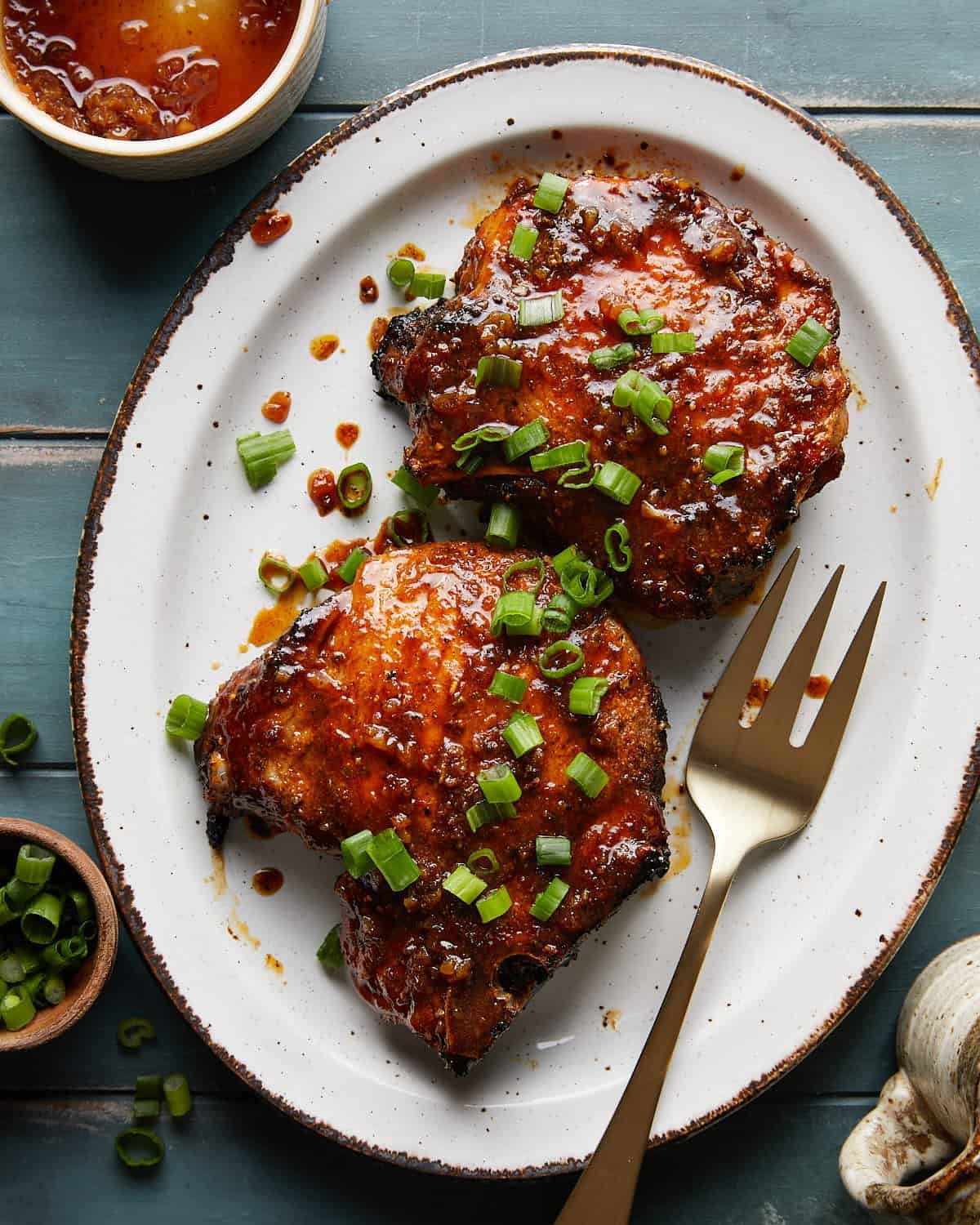 Overhead image of honey glazed pork chops with garnish.