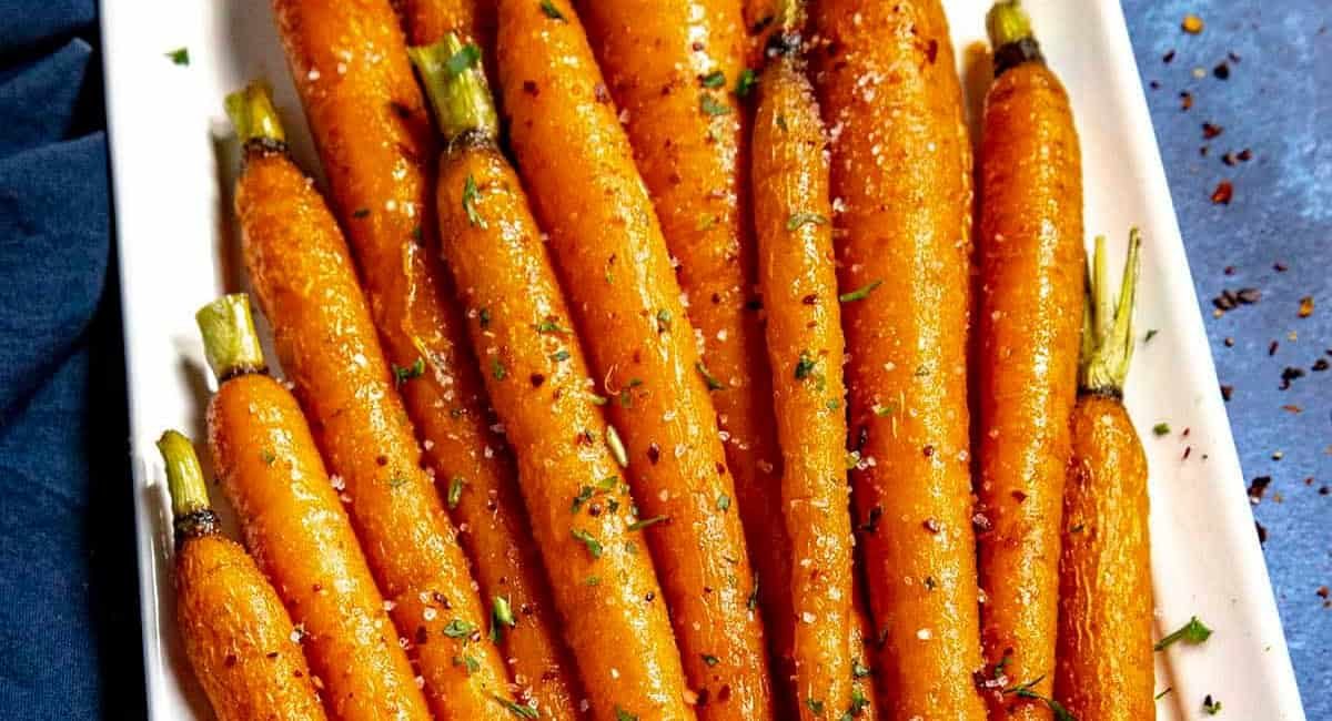 Overhead image of hot honey roasted carrots with garnish.