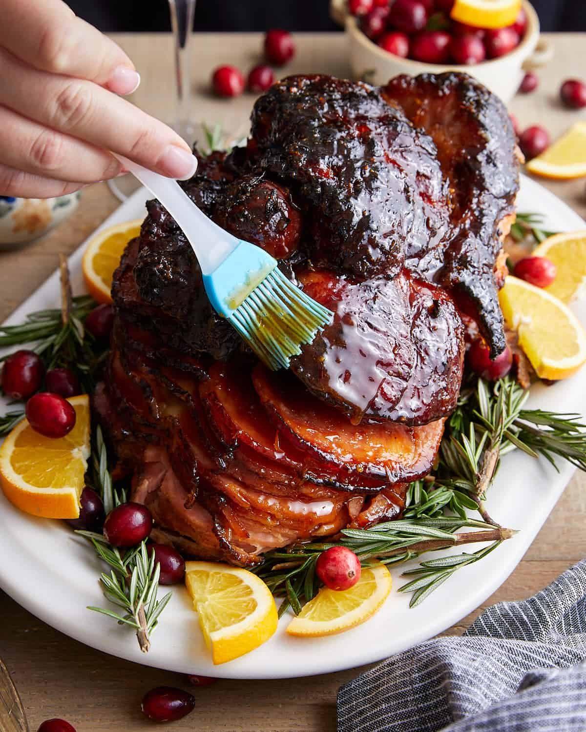 Image of spiral ham being topped with honey glaze.