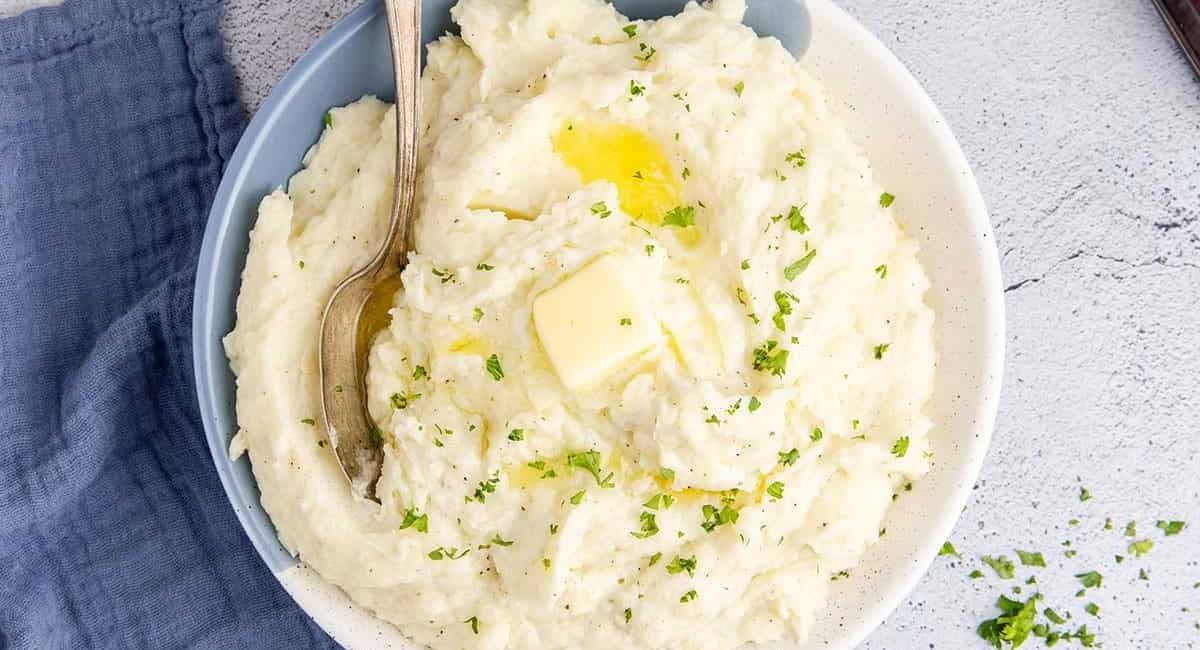 Overhead image of Idahoan mashed potatoes with garnish and butter.