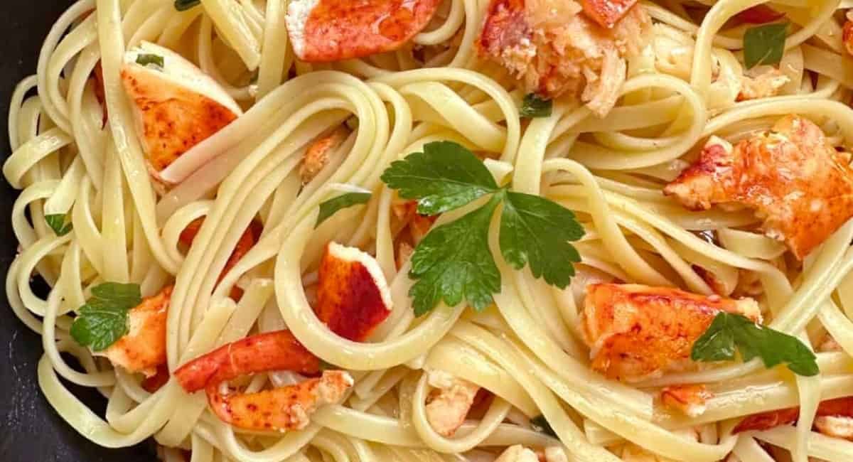 Overhead image of lobster pasta with garnish.