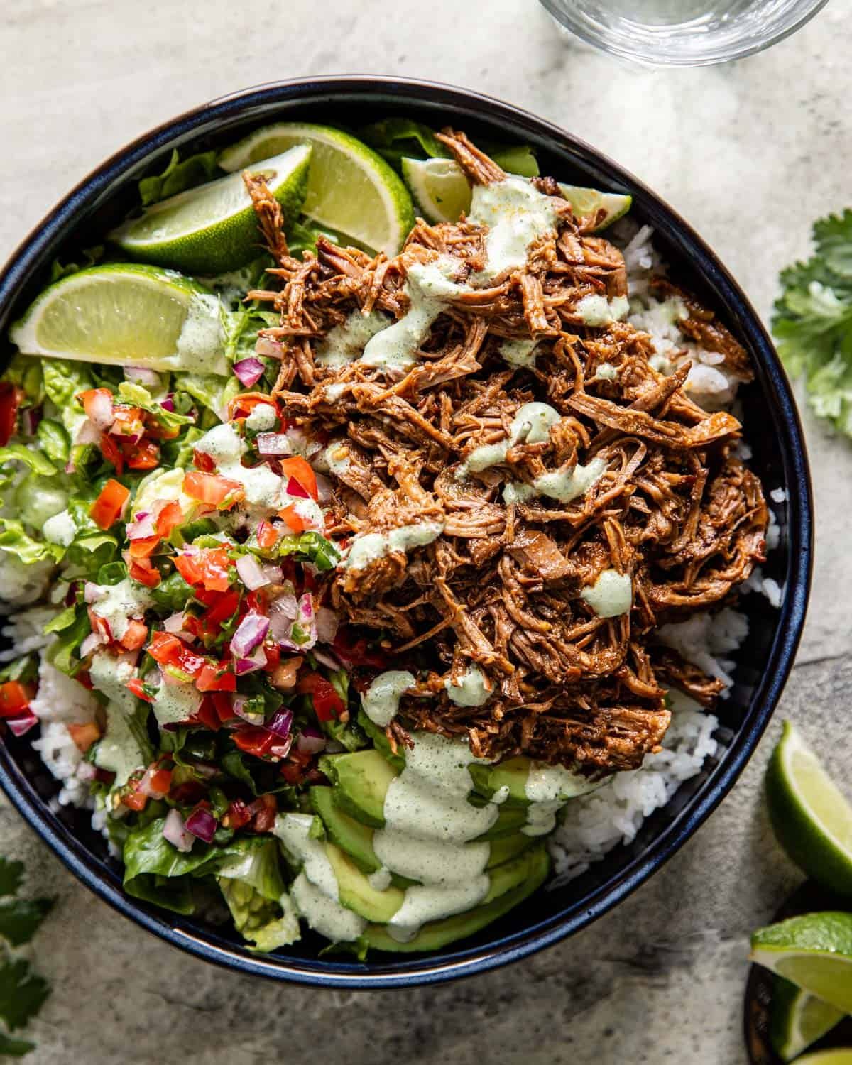 overhead of instant pot shredded beef over rice with pico and lettuce