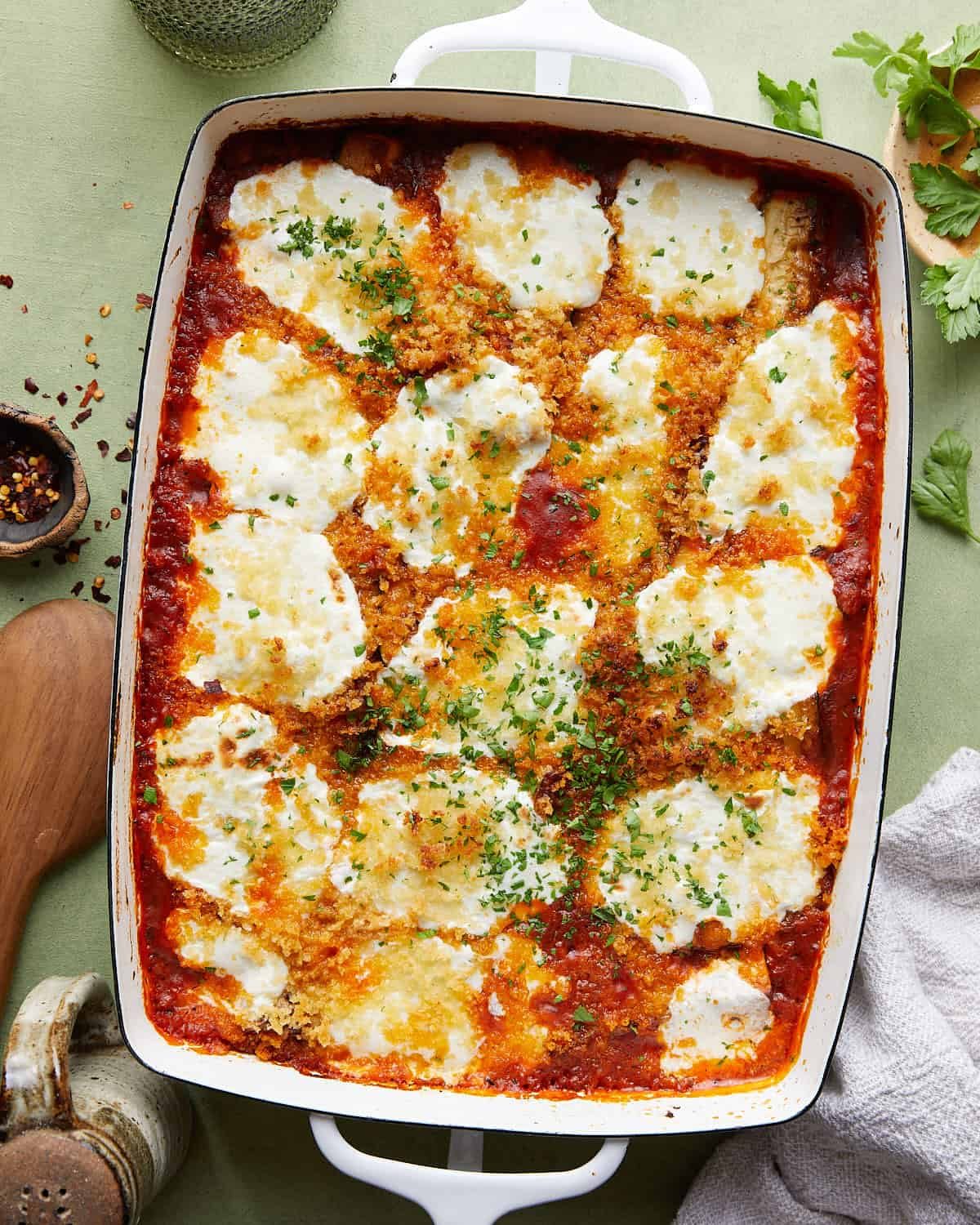 Overhead image of Italian baked zucchini with tomato sauce and cheese.