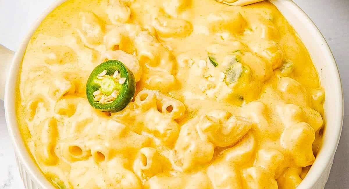 Overhead image of spicy jalapeno mac and cheese in white dish with jalapeno slice garnish.