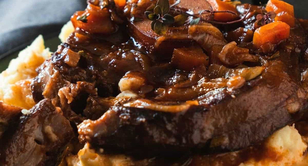 Up close image of braised lam shoulder chops with garnish.