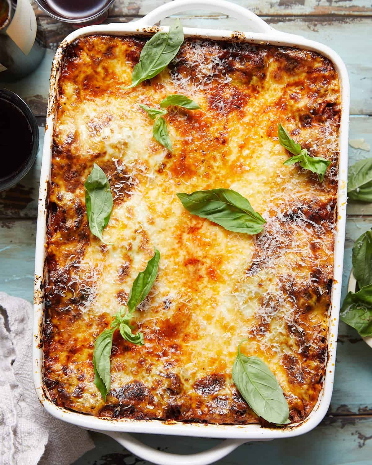 Overhead image of lasagna with bechamel sauce in white dish.