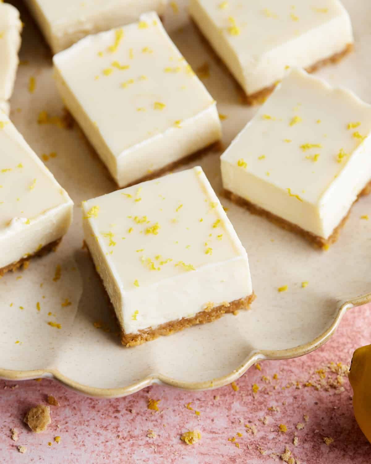 Overhead image of lemon bars with graham cracker crust on white plate.