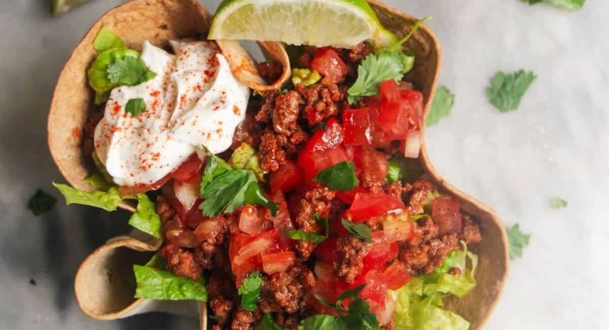 Overhead image of loaded beef burrito bowls with crispy tortilla shells.