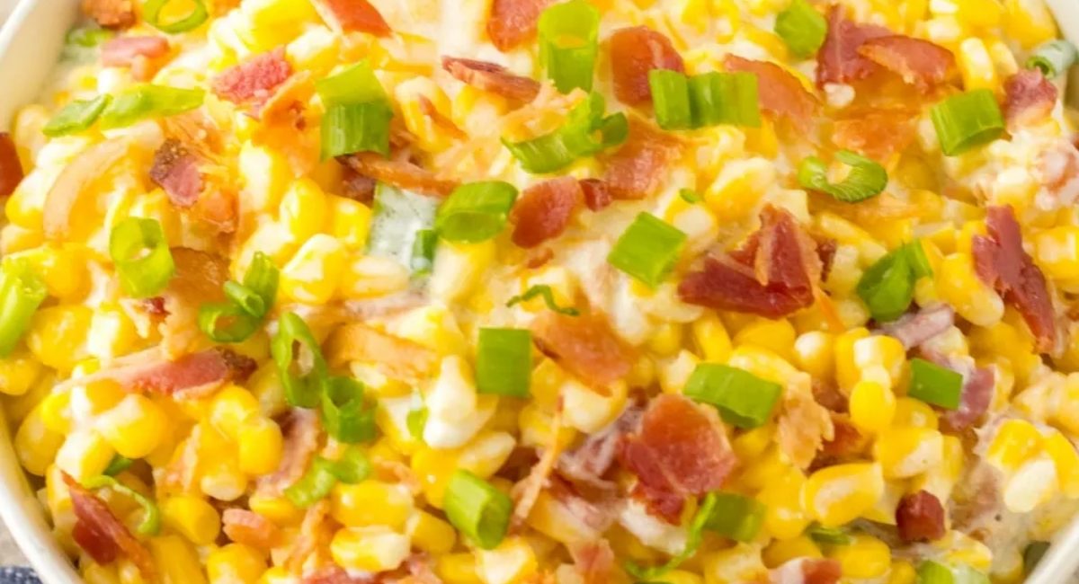 Overhead image of full loaded slow cooker cream corn with garnish.
