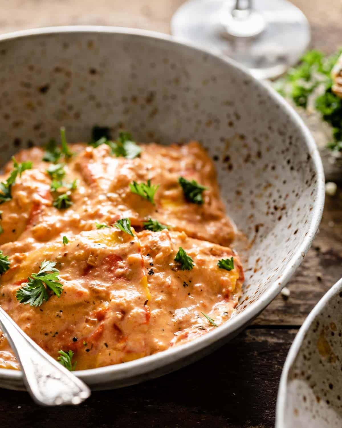 side shot of lobster ravioli and sauce in a bowl