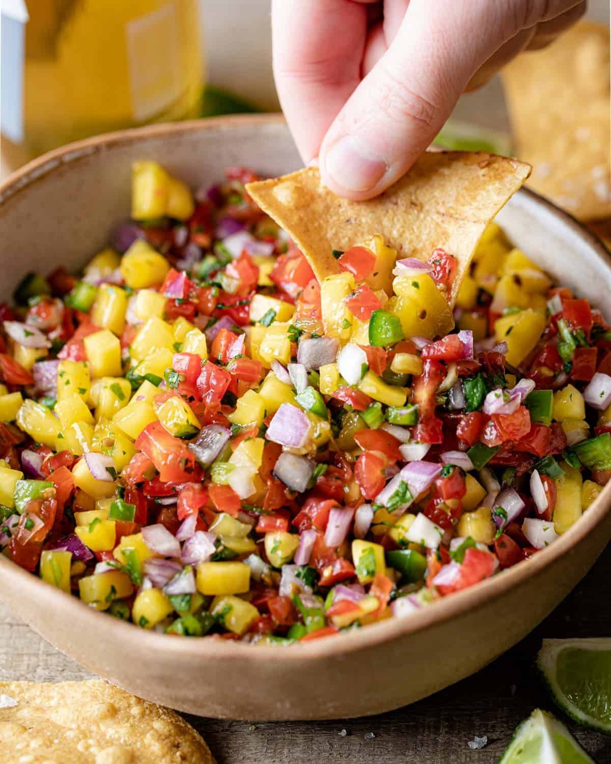 tortilla dipping into the mango pico de gallo