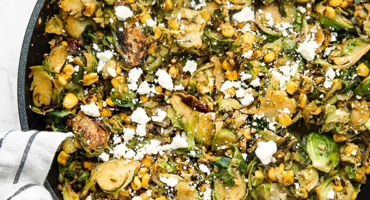 Overhead and up close image of Mexican chipotle brussel sprouts with garnish.
