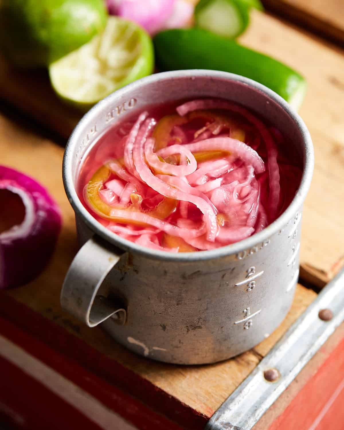 Mexican pickled onions in a metal cup.