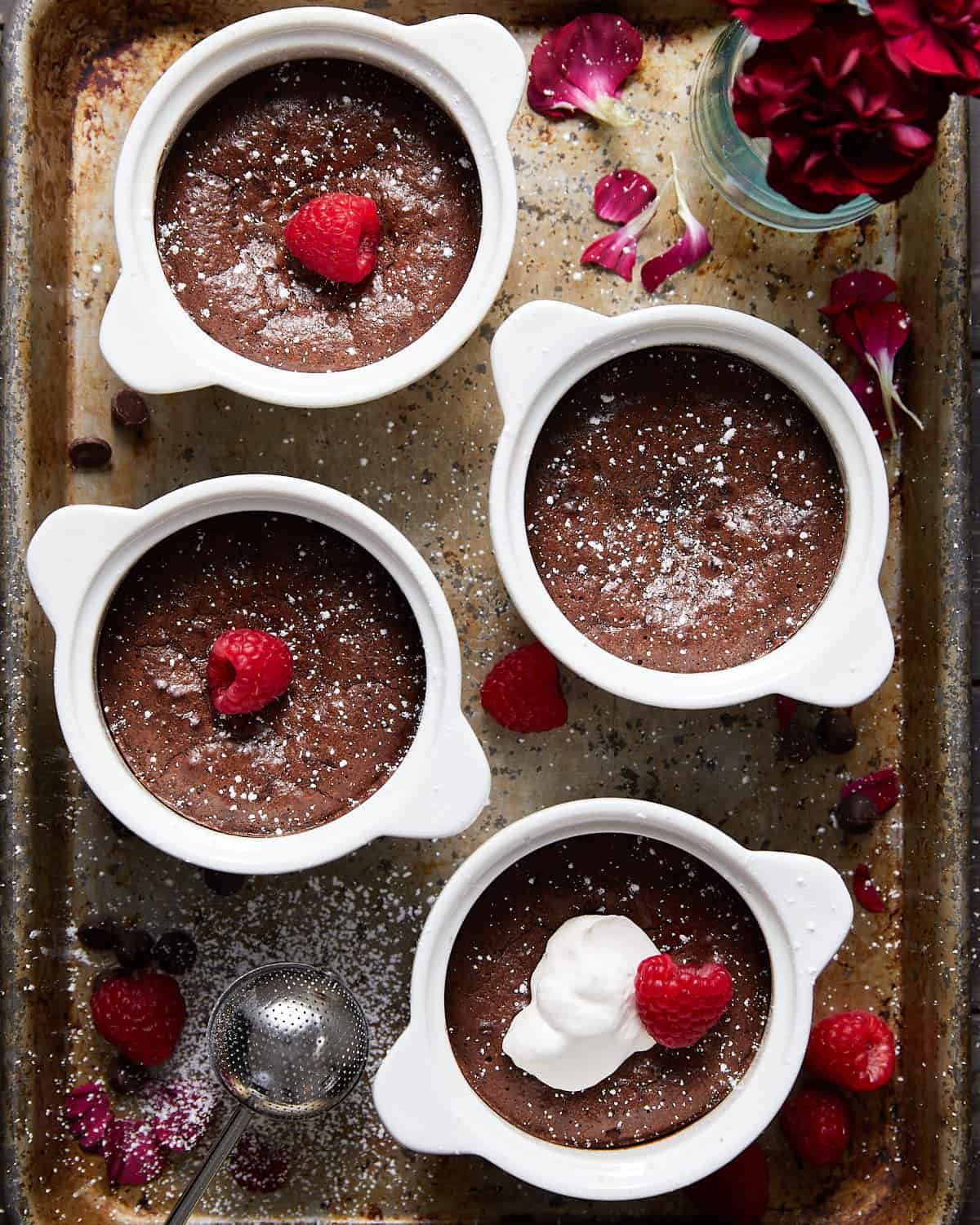 Overhead image of mini flourless chocolate cakes in white dishes.