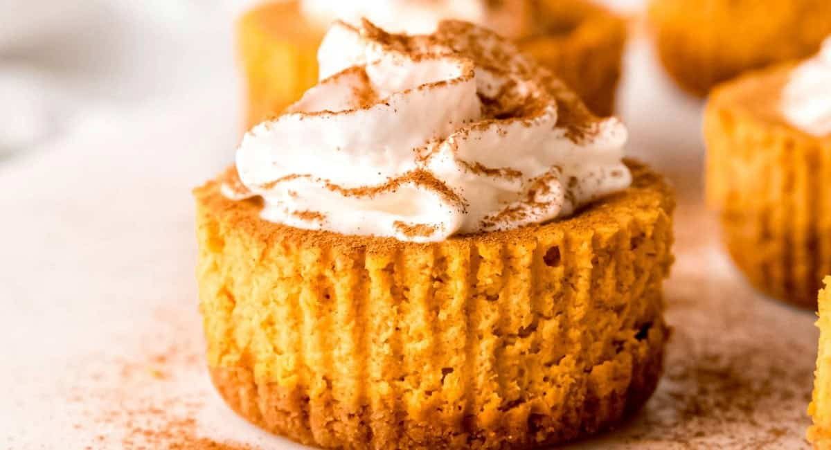 Up close side image of muffin pan mini pumpkin cheesecakes.