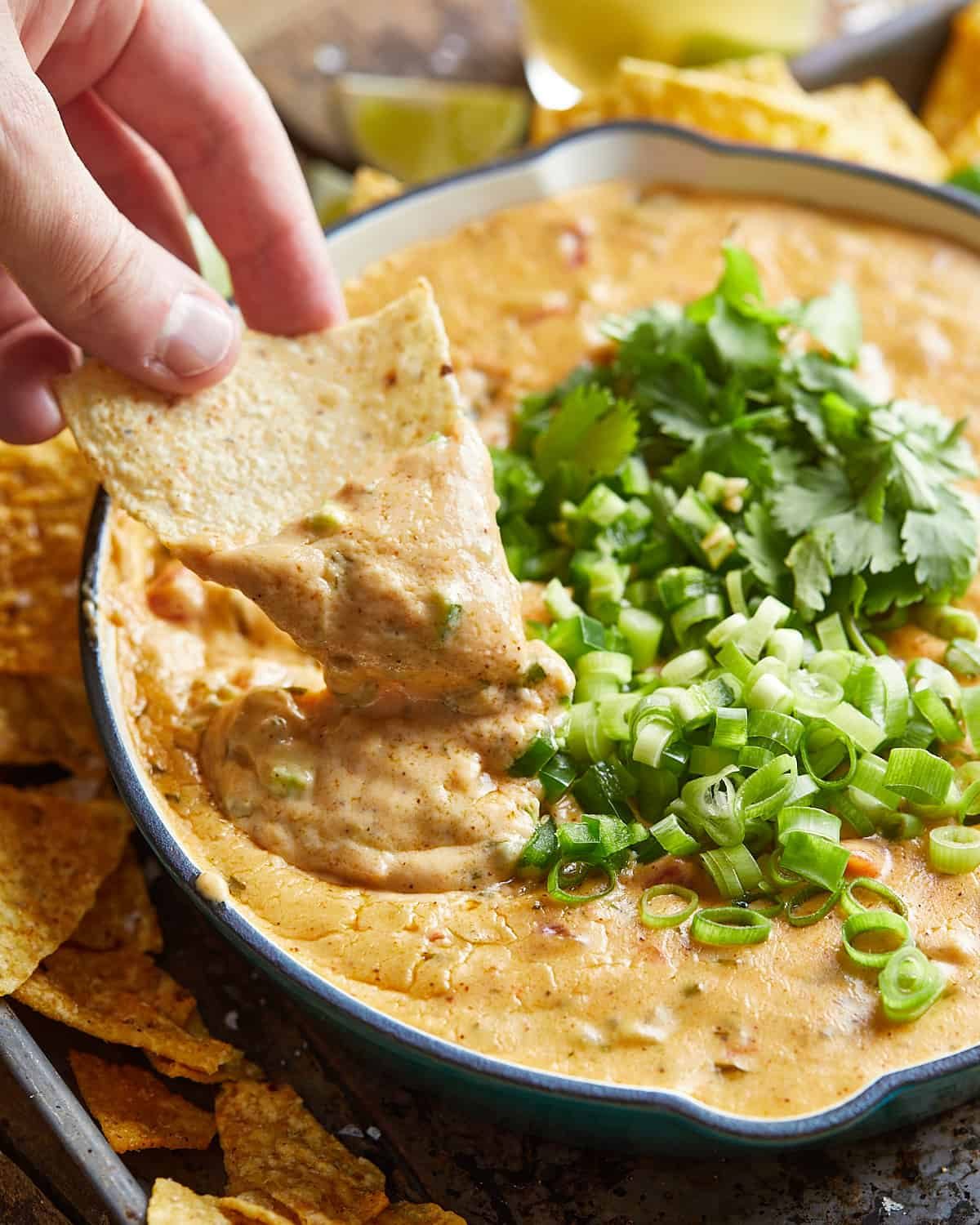 Side shot of chip being dipped into mozzarella queso.