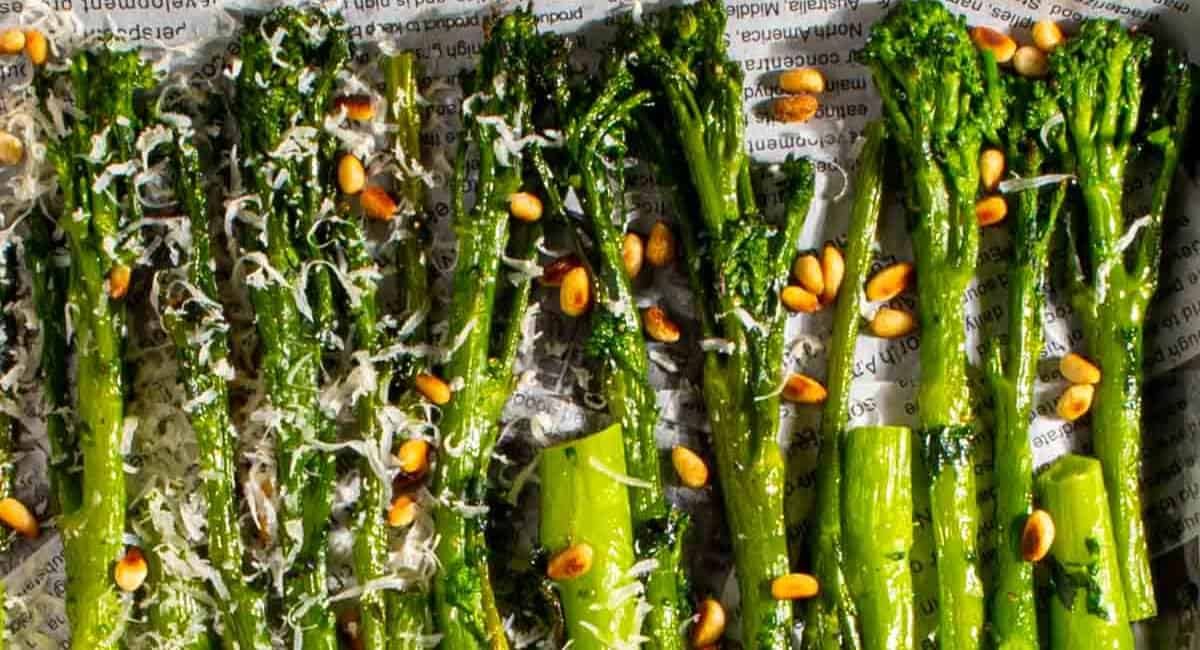 Up close image of roasted broccoli with parmesan and pine nuts.