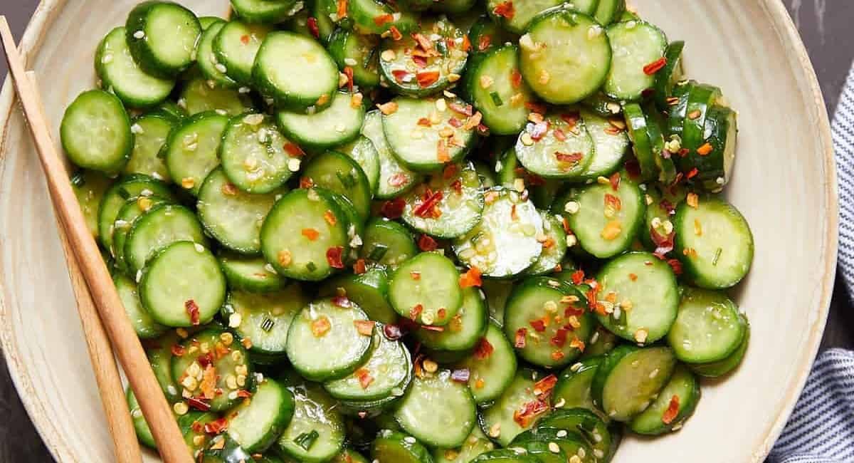 Overhead image of spicy cucumber salad in white dish.