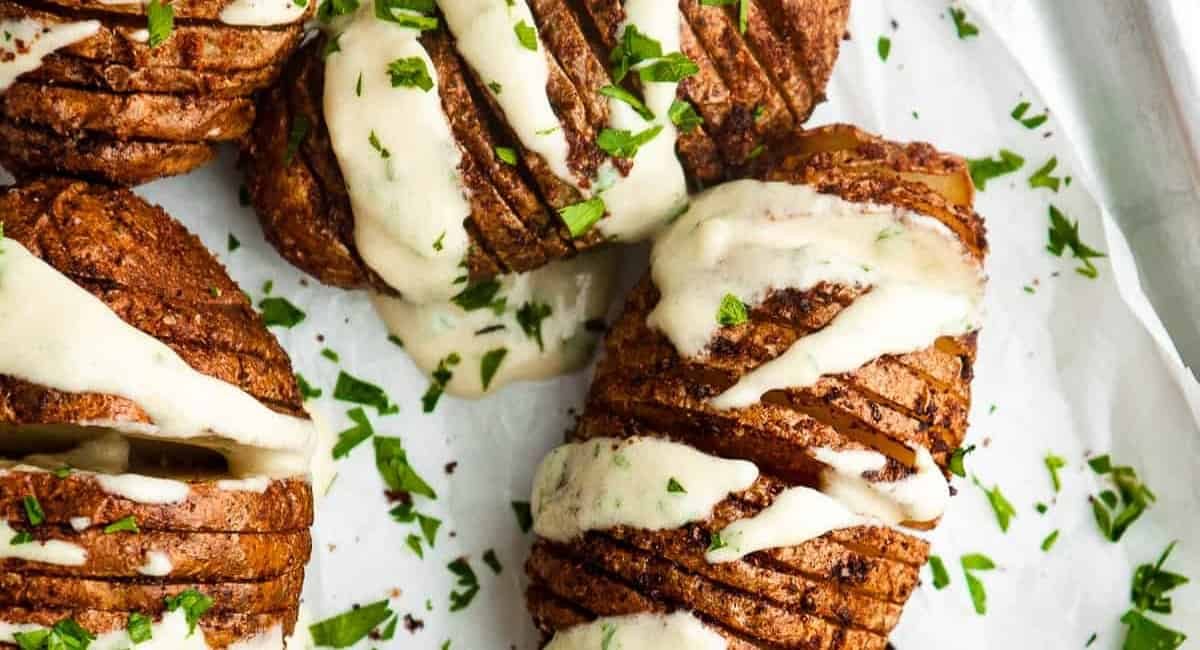 Overhead image of air fryer hasselback potates with garnish.