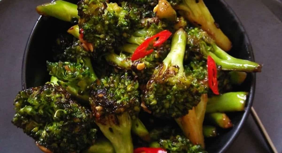 Overhead image of asian broccoli stir fry in black bowl.