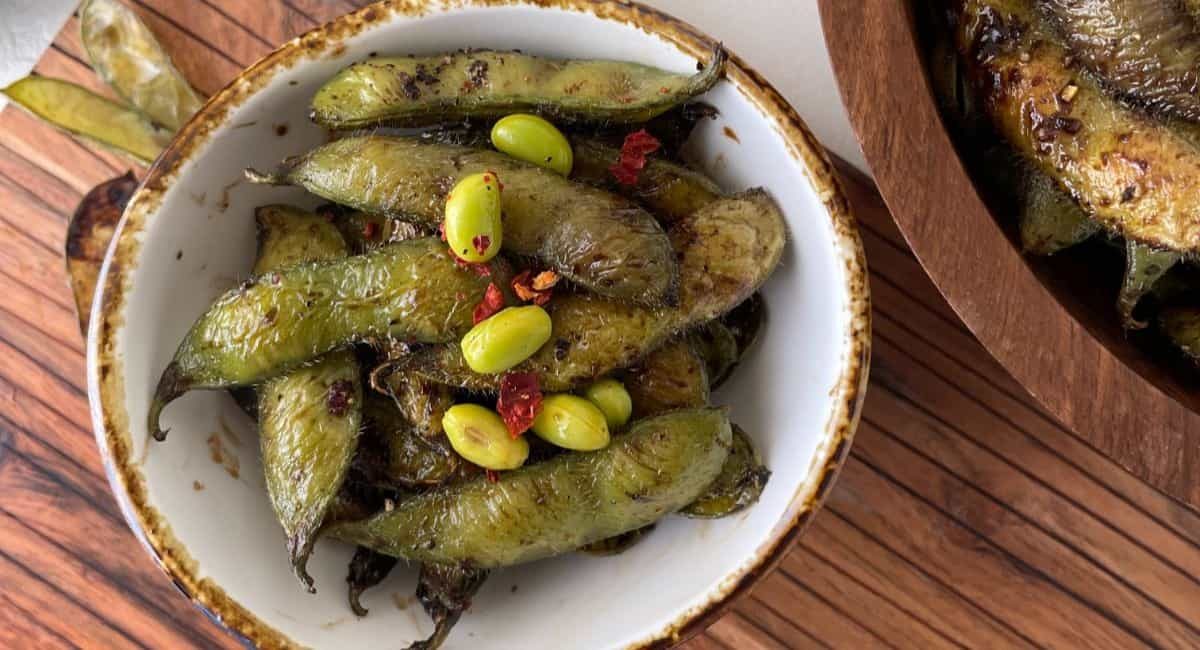 Overhead image of spicy garlic edamame in white dish.