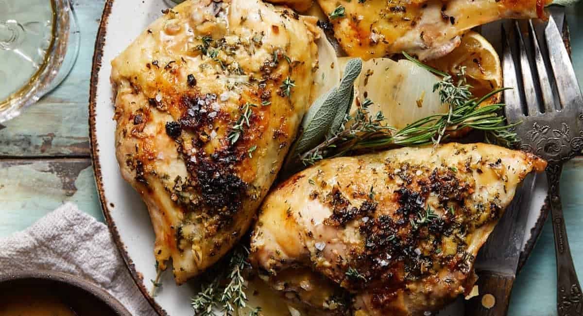 Overhead image of dutch oven chicken breasts with garnish.