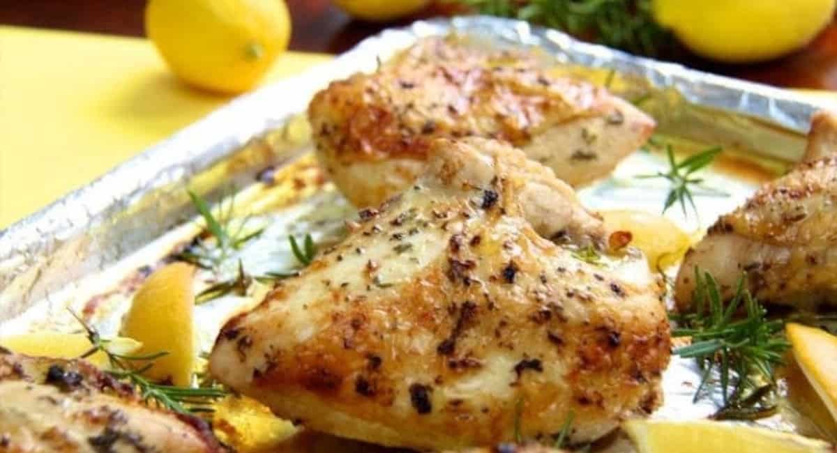 Up close image of roasted chicken breasts with lemon, garlic, and rosemary.