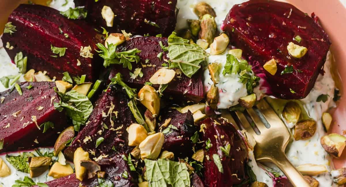 Up close image of roasted beets with herby skyr and pistachios.
