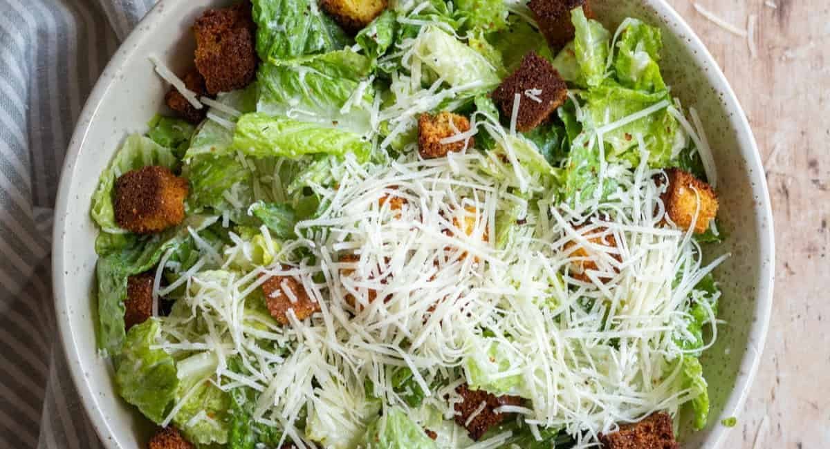 Overhead image of caesar salad with cornbread croutons and garnish.