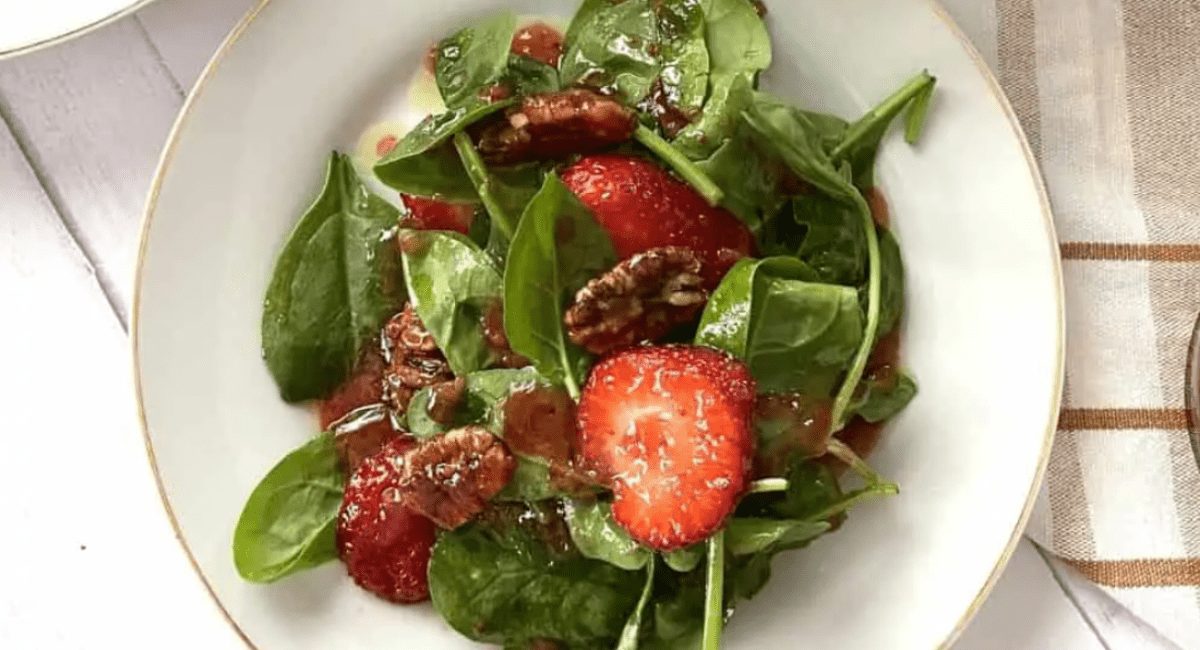 Overhead image of spinach salad with strawberry vinaigrette.