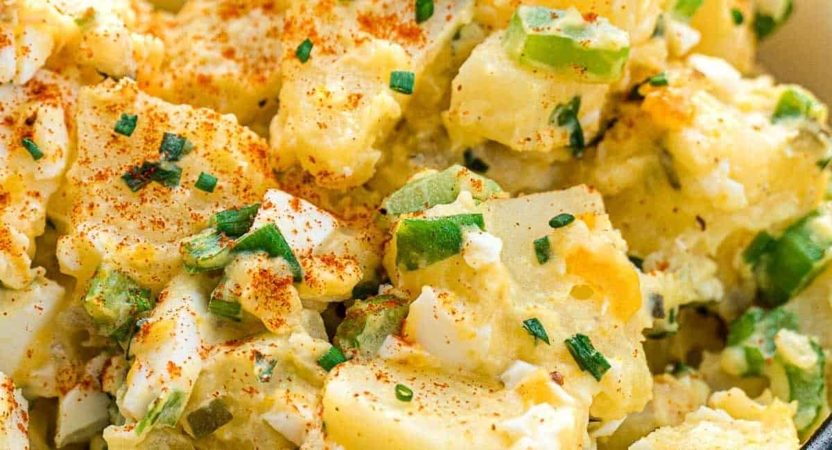 Close up image of potato salad with garnish.
