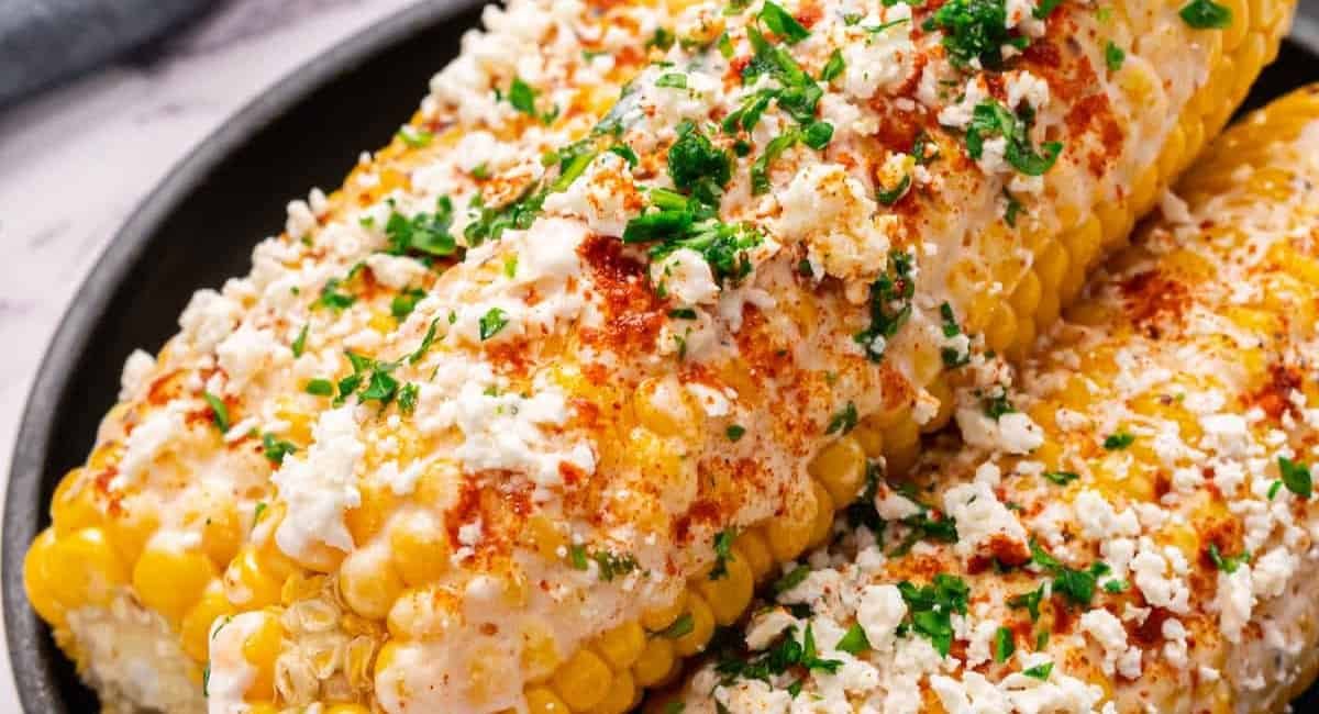 Up close image of mexican street corn with garnish.