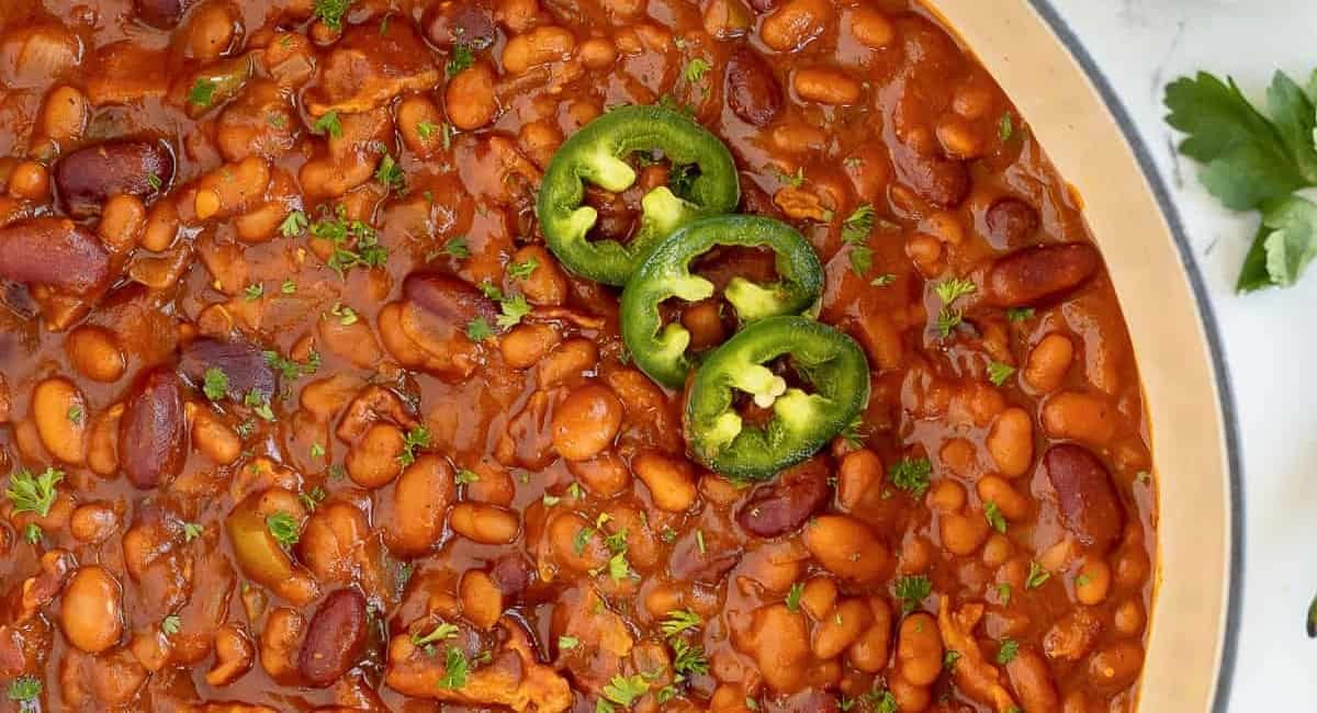 Overhead image of spicy baked beans with garnish.