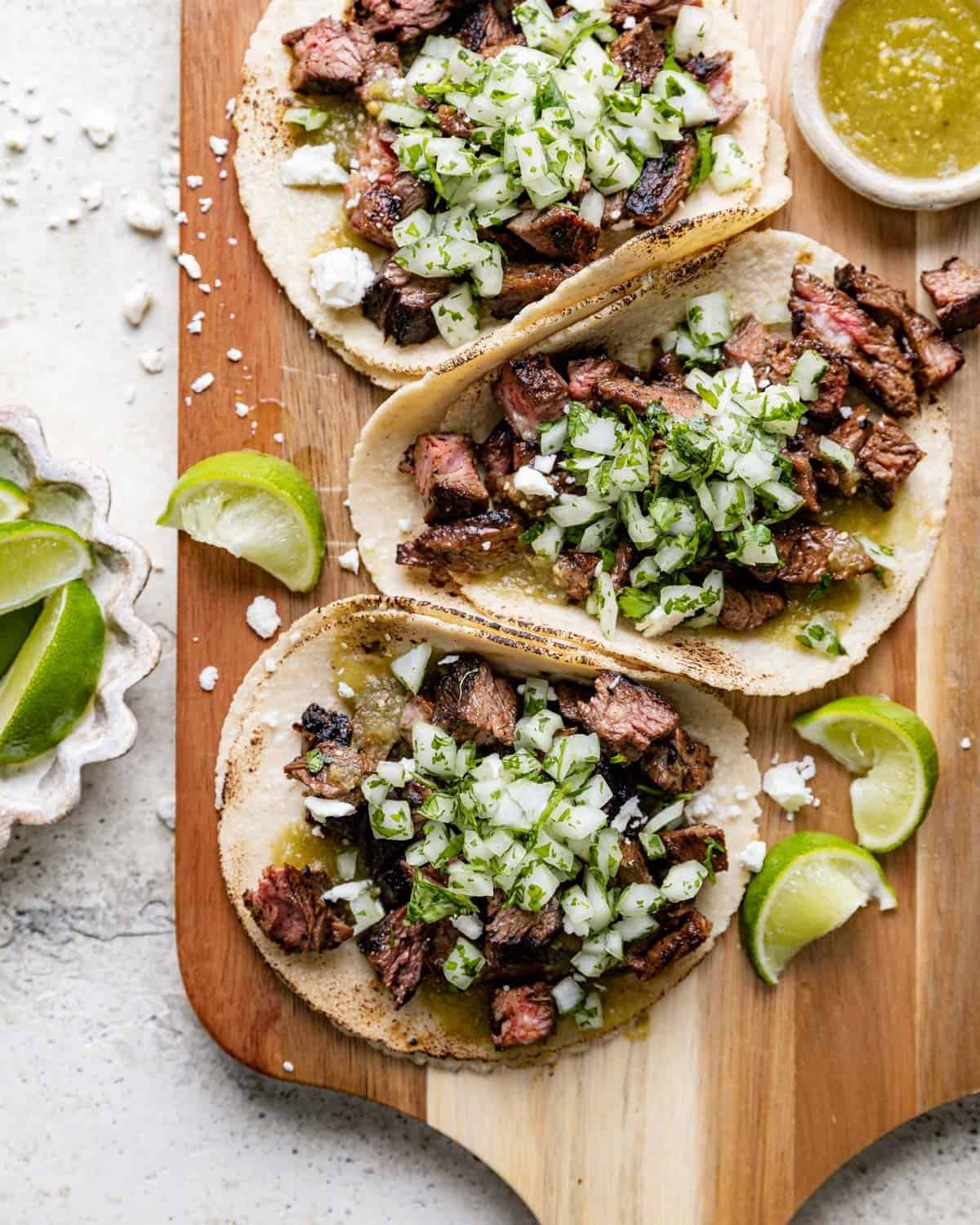 Steak street tacos on wooden board.