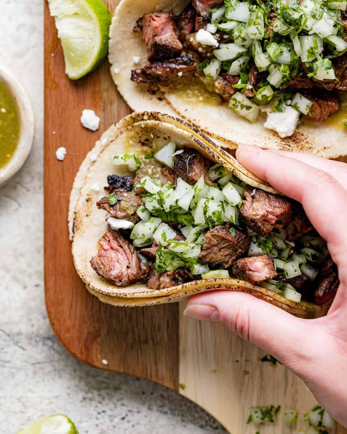 Hand holding a steak street taco.