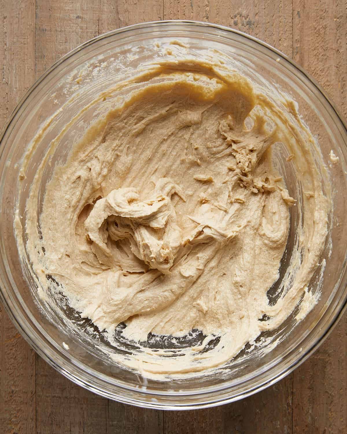 Overhead image of water, leaveners, and salt being added to the dough for no chill chocolate chip cookies, an essential step for proper rise, texture, and flavor.