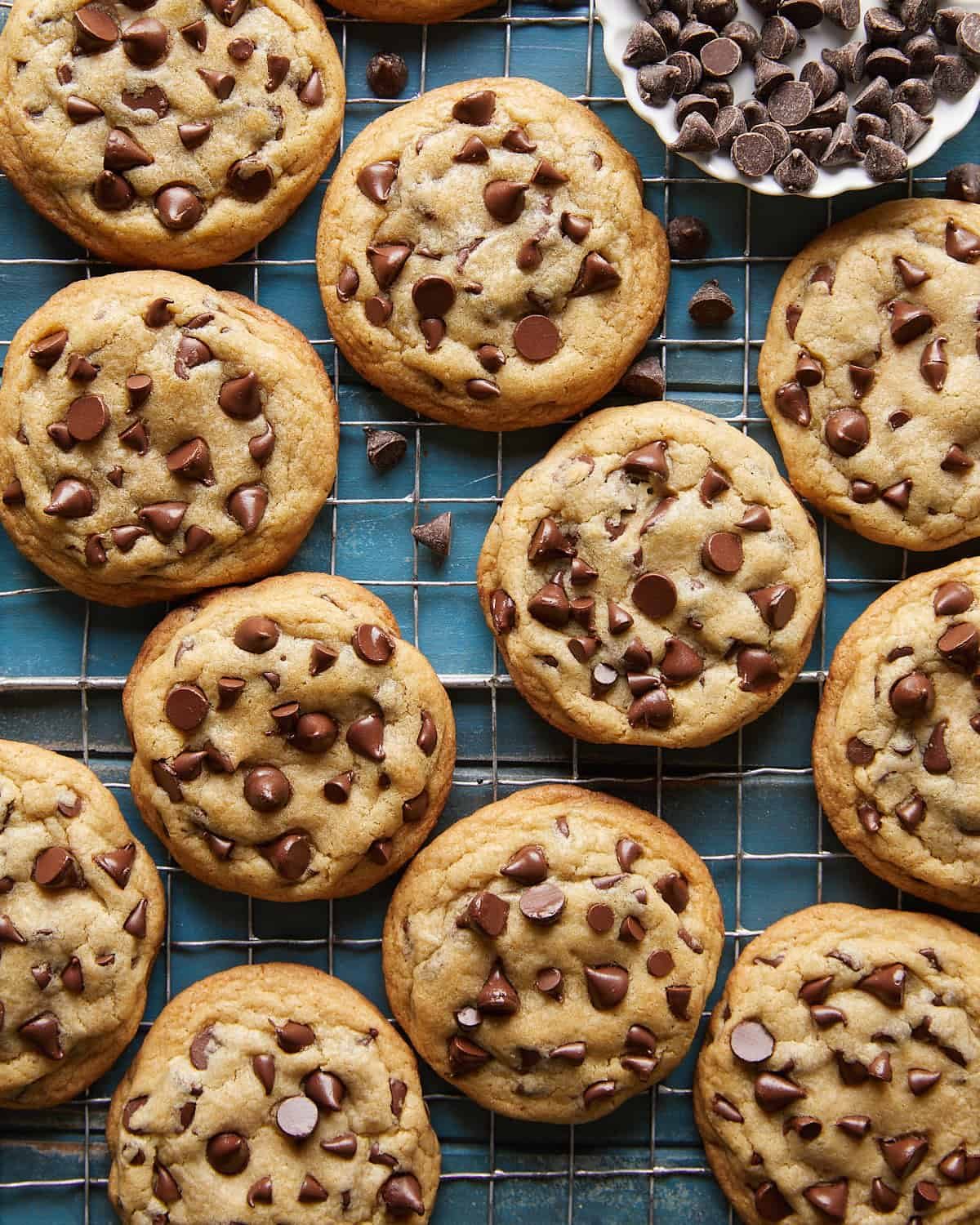 Overhead view of freshly baked no chill chocolate chip cookies cooling on a wire rack, featuring golden edges, soft centers, and melty chocolate chips for an easy homemade cookie recipe.
