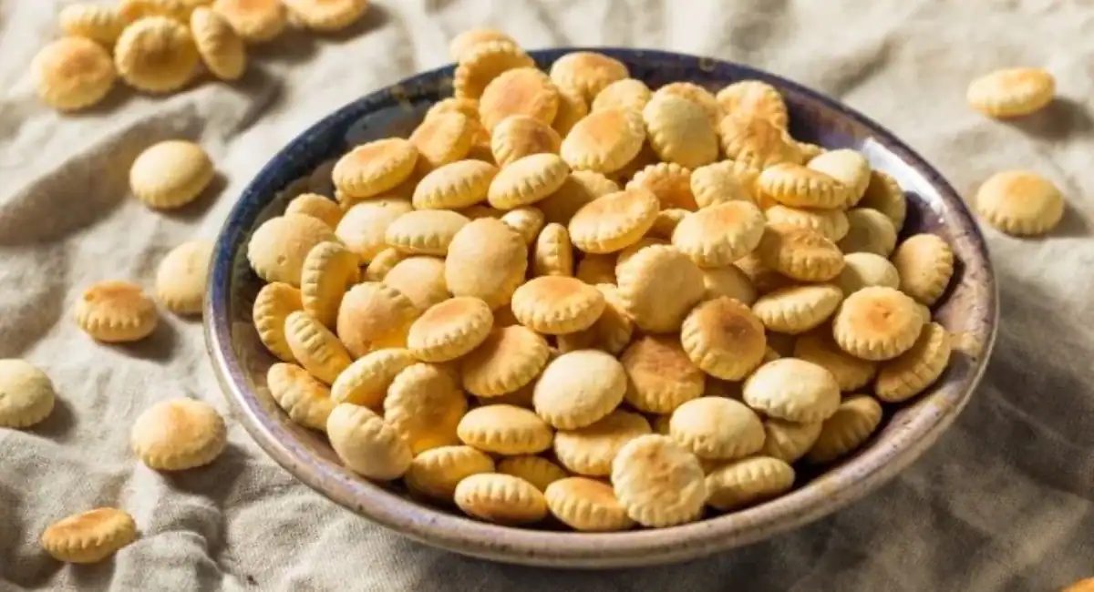 Up close overhead image of oyster crackers in brown bowl.