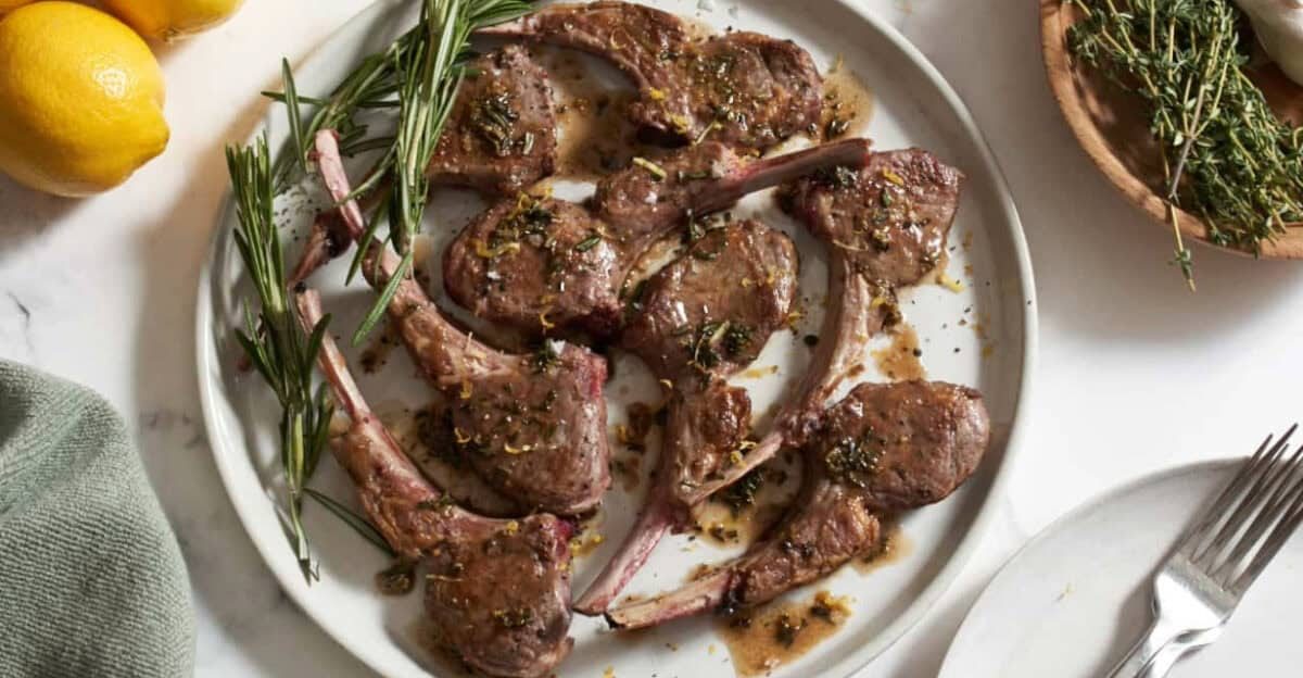 Overhead image of pan seared lamb chops with rosemary garnish.