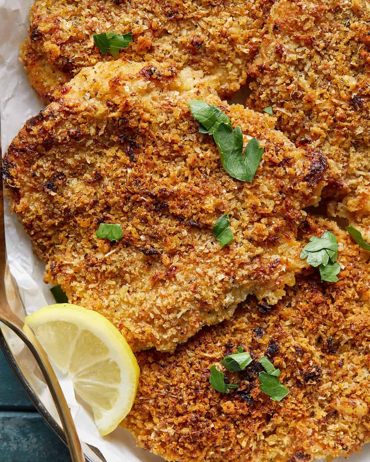 Close-up of the golden Parmesan-panko topping on baked chicken breasts.