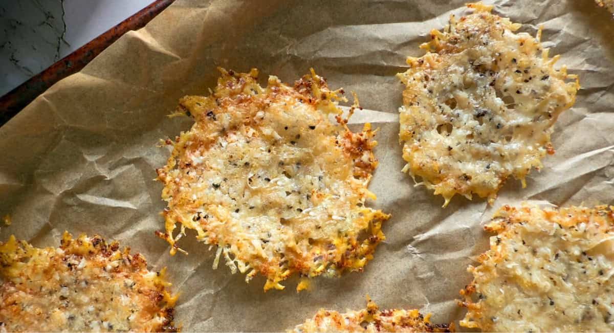 Up close overhead image of parmesan chips on parchment paper.